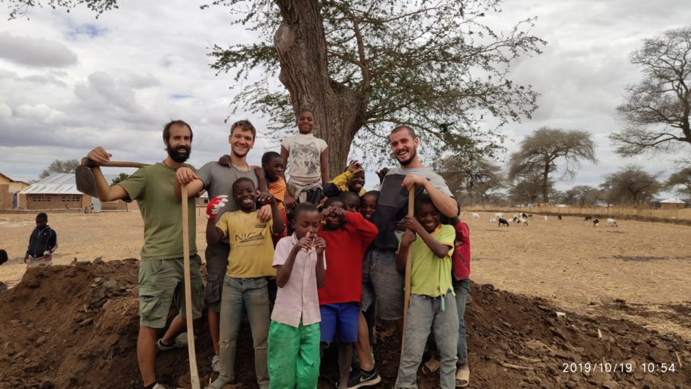 Noi volontari maschi assieme ad alcuni ragazzi del centro orfani durante la concimazione dei campi.